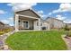 Well-maintained backyard featuring a covered patio, beautiful green lawn, and lovely landscaping at 16840 New Autumn Dr, Monument, CO 80132
