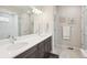 Bathroom featuring double sinks with quartz countertops, modern lighting, tile floors, and a glass-enclosed shower at 16840 New Autumn Dr, Monument, CO 80132