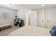 Bright bedroom featuring a bench, shelving unit, and doors to the closet and bathroom at 16840 New Autumn Dr, Monument, CO 80132