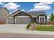 Charming gray home with a three car garage and beautifully xeriscaped front yard at 16840 New Autumn Dr, Monument, CO 80132