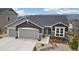 Charming gray home with a three car garage and beautifully xeriscaped front yard at 16840 New Autumn Dr, Monument, CO 80132