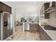 Open kitchen with stainless steel appliances, a tile backsplash, and hardwood floors with views to the living room at 16840 New Autumn Dr, Monument, CO 80132