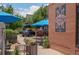Inviting outdoor seating area adjacent to the coffee shop, shaded by blue umbrellas at 558 N Washington St # 305, Denver, CO 80203
