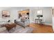 Bright living room featuring hardwood floors, modern furnishings, and an open layout into the kitchen and dining area at 558 N Washington St # 305, Denver, CO 80203