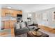 Open-concept living area with a modern sofa, hardwood floors, and a view of the kitchen and front door at 558 N Washington St # 305, Denver, CO 80203