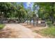 Park playground featuring swings and slide surrounded by trees at 558 N Washington St # 305, Denver, CO 80203
