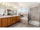 Primary bathroom showcasing a double vanity, soaking tub, glass shower and wood cabinets at 9610 S Dover Way, Littleton, CO 80127