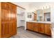 Bathroom featuring a double vanity, wood cabinets, and a closet with sliding wooden door at 9610 S Dover Way, Littleton, CO 80127
