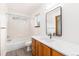 Bathroom featuring a tiled shower over tub, a window, and a single vanity with quartz countertop at 9610 S Dover Way, Littleton, CO 80127