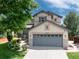A beautiful, two-story home featuring a well-maintained lawn and gray two-car garage at 9610 S Dover Way, Littleton, CO 80127