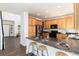 Eat-in kitchen features granite countertops, wood cabinets and breakfast bar seating at 9610 S Dover Way, Littleton, CO 80127