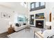 Comfortable living room with fireplace, high ceilings, and abundant natural light at 9610 S Dover Way, Littleton, CO 80127