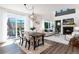 Open-concept living space with fireplace, deck access and seamlessly connecting dining area at 9610 S Dover Way, Littleton, CO 80127