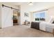 Spacious bedroom featuring carpet floors, ceiling fan and a barn door leading to the connected bathroom at 9610 S Dover Way, Littleton, CO 80127