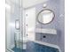 Stylish bathroom featuring blue patterned walls, hexagonal blue tile floor, and glass shower with modern fixtures at 417 S Pontiac Way, Denver, CO 80210