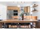 Open-concept dining area with modern light fixtures and a view of the stainless steel kitchen appliances at 417 S Pontiac Way, Denver, CO 80210