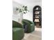 Cozy seating area with two green chairs, black side table, hardwood flooring, and a window overlooking the outdoors at 417 S Pontiac Way, Denver, CO 80210