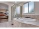Bathroom showcases tiled floor, glass enclosed shower and separate soaking tub with tile surround at 2918 W 135Th Pl, Thornton, CO 80241