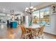 Sunlit dining area featuring hardwood floors, a wooden table, and a large window overlooking the backyard at 2918 W 135Th Pl, Thornton, CO 80241