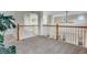 Open loft area features neutral carpeting, wood railing and offers a view of the lower level and chandelier at 2918 W 135Th Pl, Thornton, CO 80241
