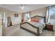 Cozy main bedroom with plush carpet, ceiling fan, tray ceiling, and a decorative upholstered bed frame at 2918 W 135Th Pl, Thornton, CO 80241