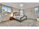 Cozy main bedroom boasts plush carpet, ceiling fan, bay window, and a decorative upholstered bed frame at 2918 W 135Th Pl, Thornton, CO 80241