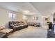 Spacious finished basement with a large sofa and ample lighting at 6212 S Ash W Cir, Centennial, CO 80121