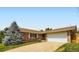 Brick home featuring an attached two-car garage, a well-manicured lawn, and mature trees at 6212 S Ash W Cir, Centennial, CO 80121