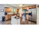 Well-appointed kitchen with wood cabinets, stainless steel appliances, and a central island at 6212 S Ash W Cir, Centennial, CO 80121