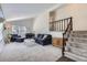 Bright living room with vaulted ceilings, neutral carpet, stairs, and cozy seating area with a piano at 6212 S Ash W Cir, Centennial, CO 80121