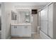 Bright bathroom featuring a double sink vanity, a large mirror, and a glass-enclosed shower at 22062 E Irish Dr, Aurora, CO 80016