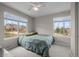 Bright bedroom featuring two windows with outside views, ceiling fan, and neutral colored walls at 22062 E Irish Dr, Aurora, CO 80016