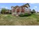 Charming home with stone accents, a red deck, and lush green lawn at 22062 E Irish Dr, Aurora, CO 80016