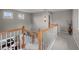 Bright hallway with wooden railings, chandelier, and access to other areas of the home at 22062 E Irish Dr, Aurora, CO 80016