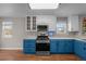 Updated kitchen with stainless steel appliances, blue lower cabinets, and bright white upper cabinets at 22062 E Irish Dr, Aurora, CO 80016