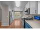 Open concept kitchen view with stainless steel refrigerator and appliances, plus blue cabinets at 22062 E Irish Dr, Aurora, CO 80016