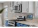 Close up of stainless steel oven and stovetop in updated kitchen, with view of digital wall display at 22062 E Irish Dr, Aurora, CO 80016