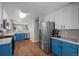 View of modern kitchen with stainless steel refrigerator and appliances, plus blue cabinets at 22062 E Irish Dr, Aurora, CO 80016