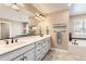 Well-lit bathroom with dual sinks, granite countertops, tiled floors, and soaking tub at 2165 Summerlin Ln, Longmont, CO 80503