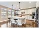 Bright kitchen features a large island with seating, quartz countertops, and stainless steel appliances at 2165 Summerlin Ln, Longmont, CO 80503