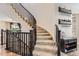 Carpeted staircase with dark railing and nearby dark wood console table at 2165 Summerlin Ln, Longmont, CO 80503