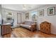 Bright bedroom with hardwood floors, a futon, and natural light from two windows at 5445 Reed Ct, Arvada, CO 80002