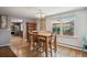 Sunlit dining room featuring hardwood floors, a chandelier, and a view of the neighborhood through a window at 5445 Reed Ct, Arvada, CO 80002