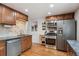 Modern kitchen featuring stainless steel appliances, wooden cabinets, and tiled backsplash at 5445 Reed Ct, Arvada, CO 80002