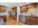 Spacious kitchen featuring ample cabinetry, wood floors, tiled backsplash, and stainless steel appliances at 5445 Reed Ct, Arvada, CO 80002