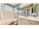 Bright bathroom features a tub, white vanity, and a decorative mirror for a clean and inviting space at 2266 S Kenton St, Aurora, CO 80014
