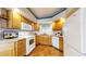 Functional kitchen featuring wood cabinetry, white appliances, and a view of the neighborhood at 2266 S Kenton St, Aurora, CO 80014