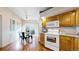 Kitchen with wood cabinets, white appliances, hardwood floors, and an adjacent dining area at 2266 S Kenton St, Aurora, CO 80014