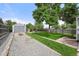 Spacious backyard with a detached garage, lush lawn, and inviting outdoor space at 5115 Osceola St, Denver, CO 80212