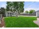 Lush green backyard with a mature tree, fence, and path to the back of the property at 5115 Osceola St, Denver, CO 80212